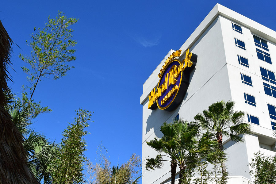 The Seminole Hard Rock Hotel and Casino logo is displayed on one side of the hotel, as seen from the tropical-themed pool area